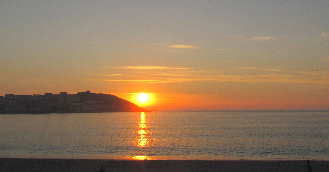 Imaxe da posta do sol dende a praia de Riazor na Coruña